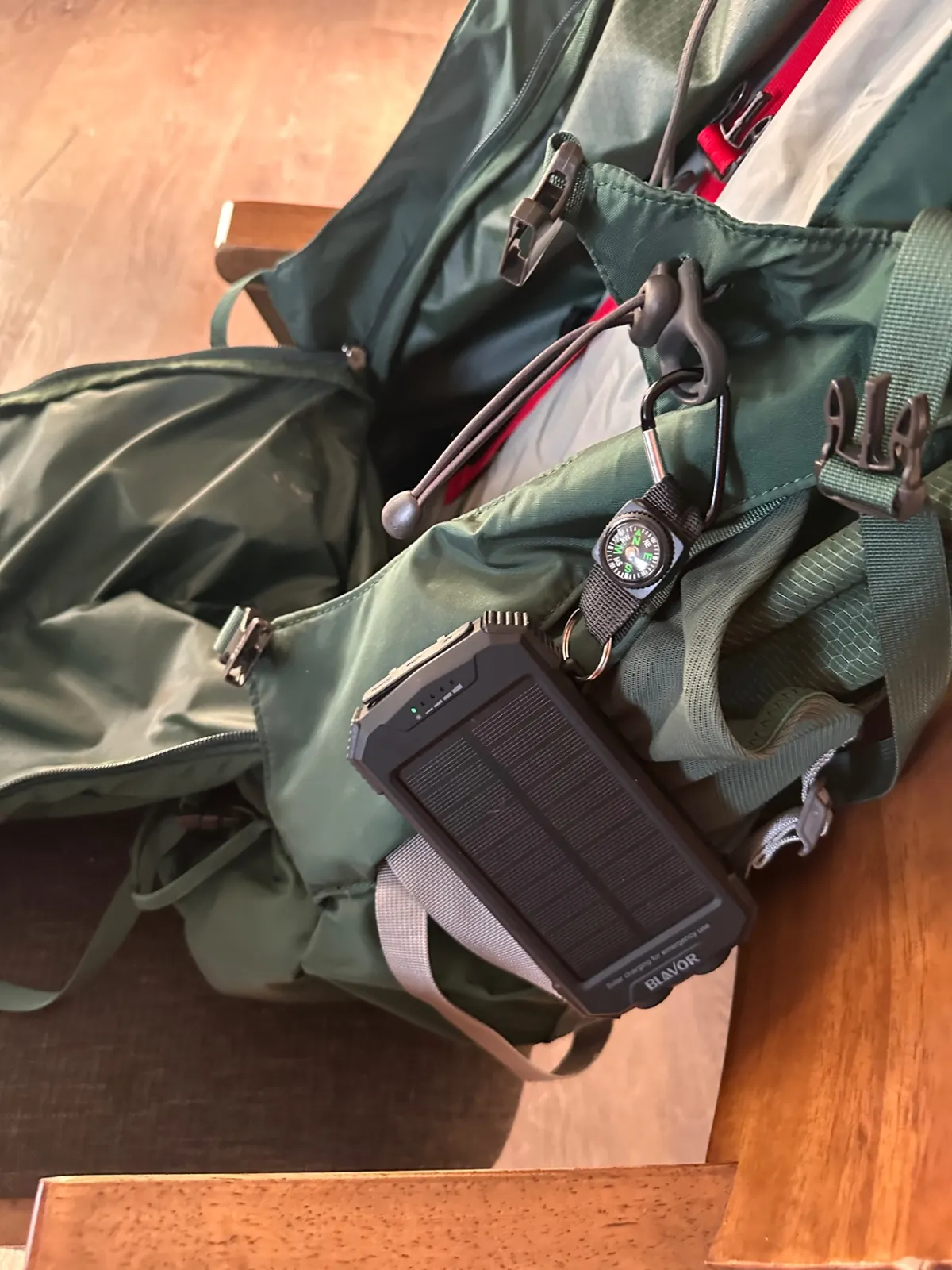 Solar power bank and compass clipped to the outside of the pack