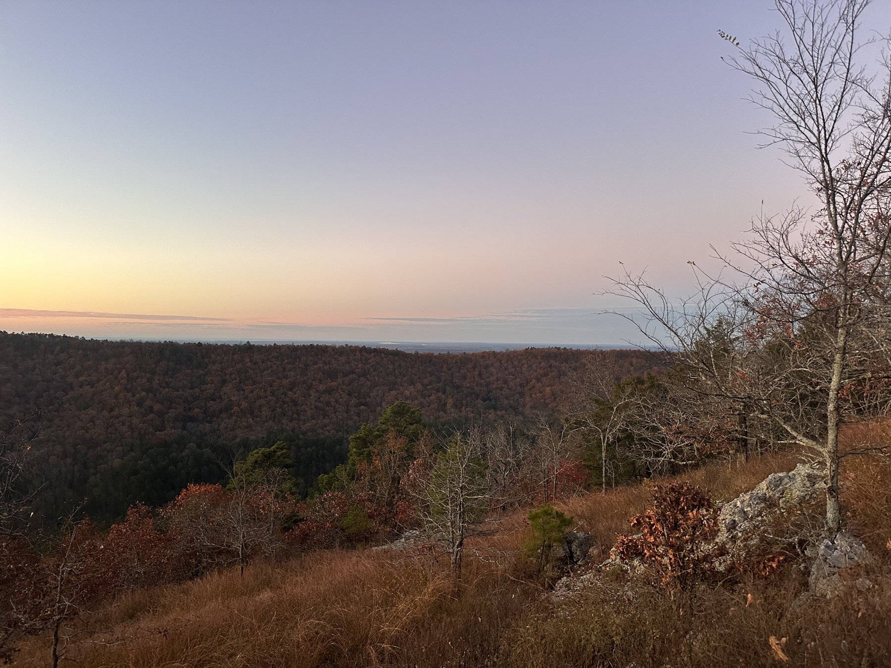 Sunrise breaking over distant blue mountain ridges