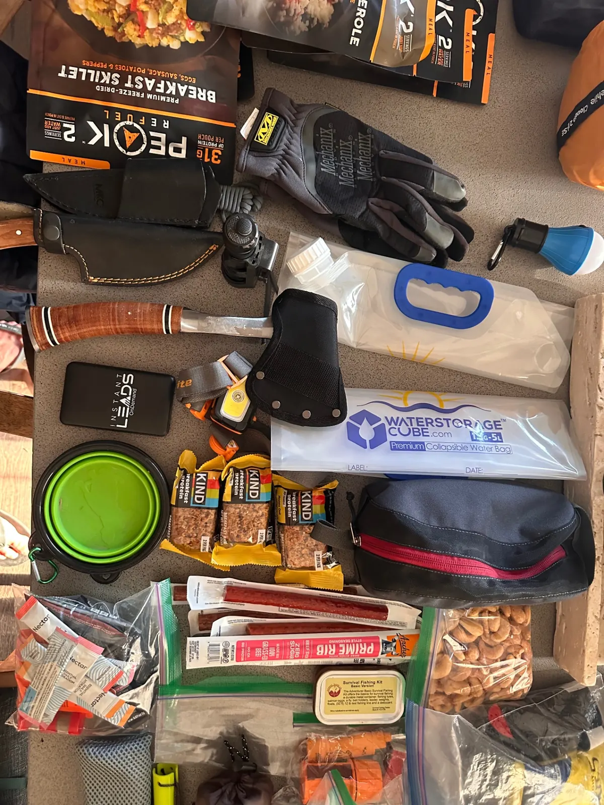 Knife, axe, headlamp, water storage, snacks, and toiletry kit