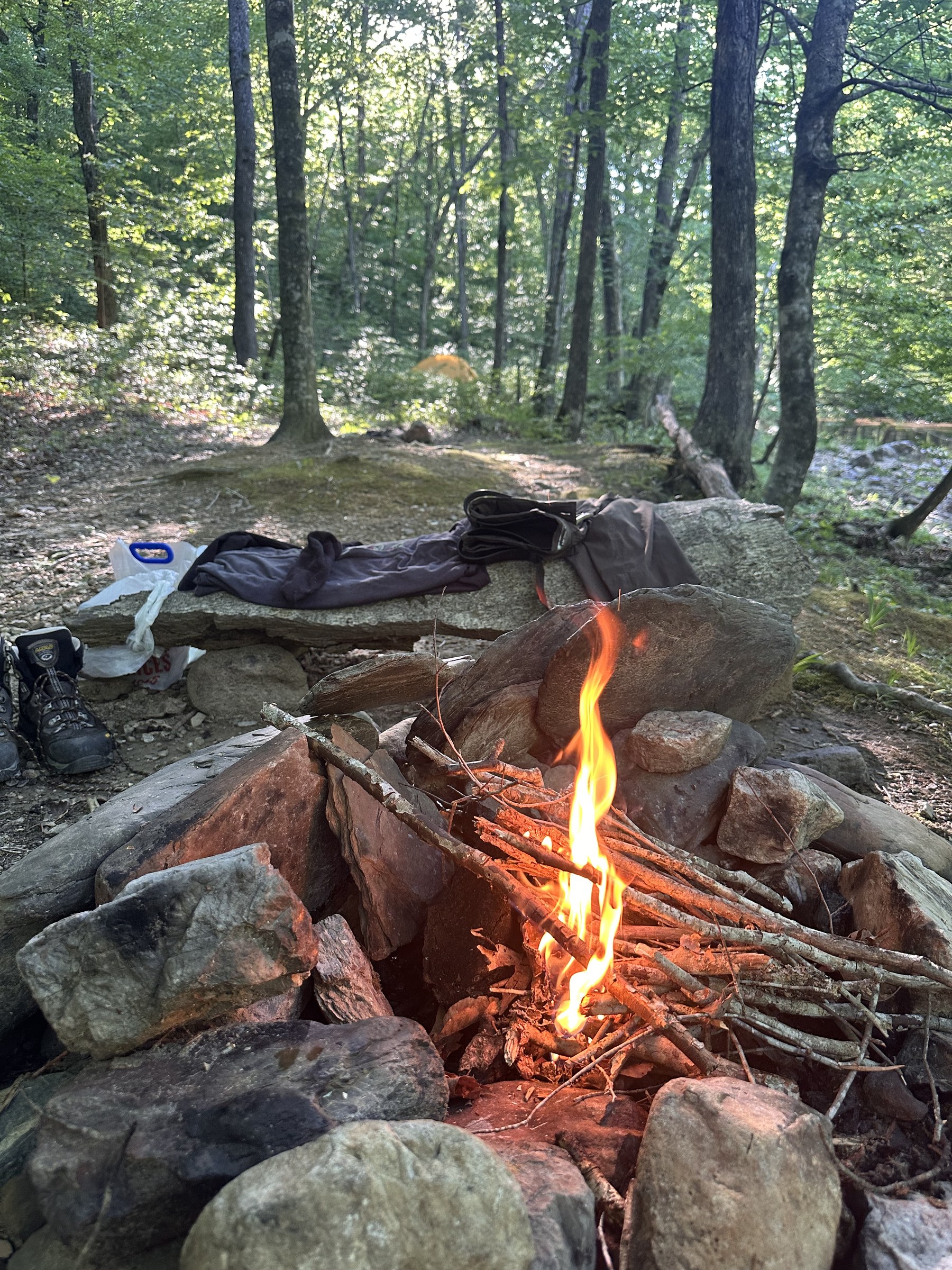 Small campfire burning inside a ring of river stones